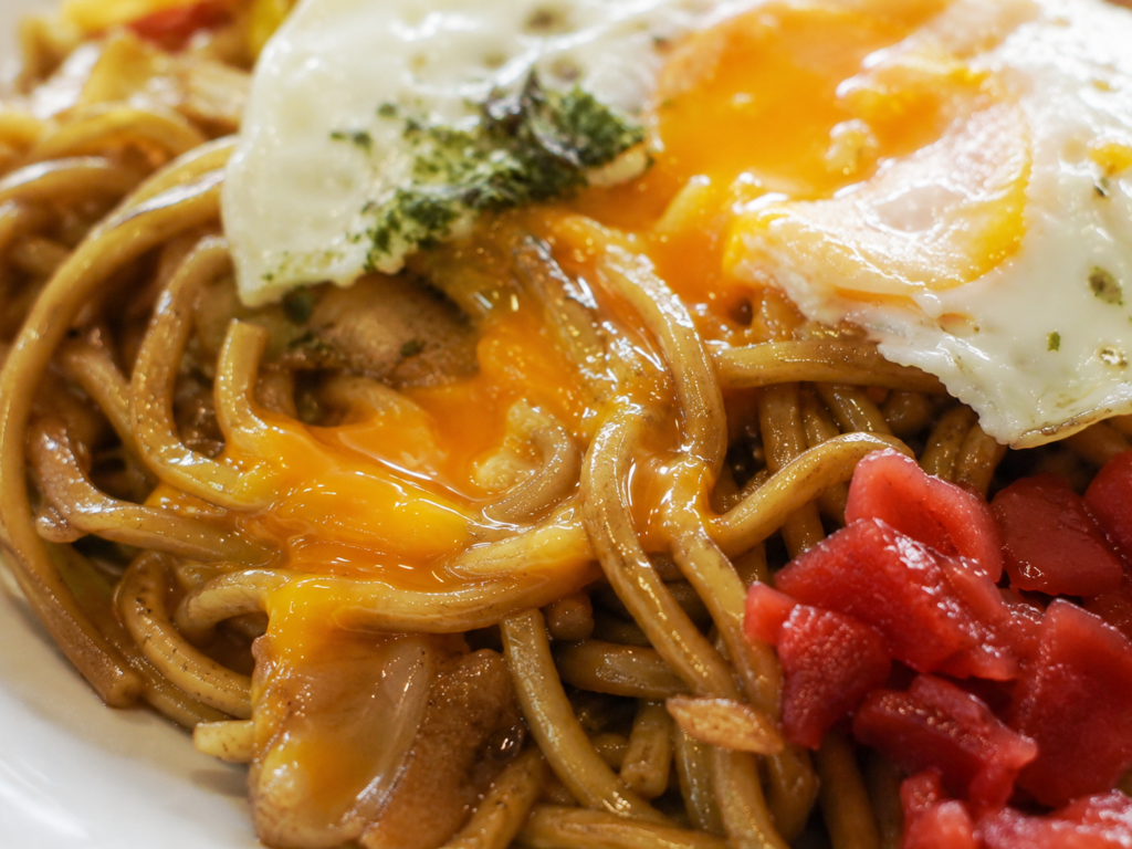 目玉焼きの黄身をからめて食べる横手やきそば