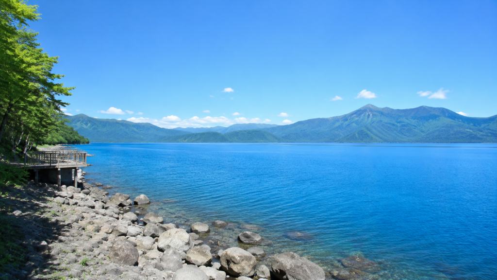 夏の田沢湖の青い湖面と山並み